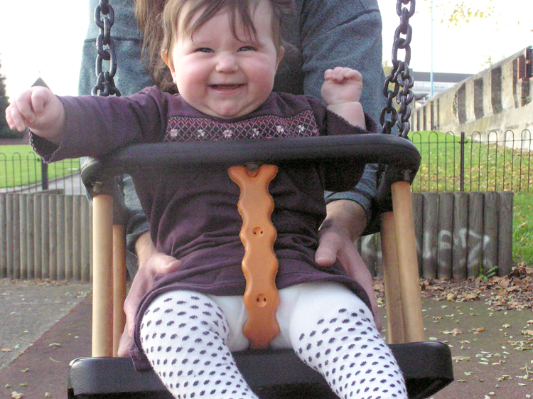 Ivy plays on the swings for the first time